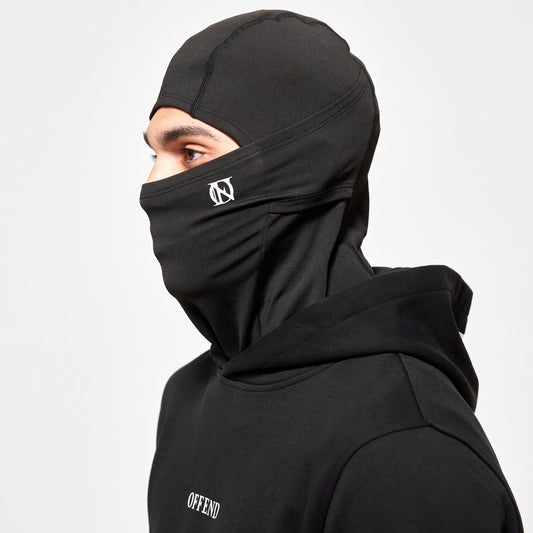 Close up of model wearing 'OFFEND' balaclava with white 'OFFEND' logo on cheek