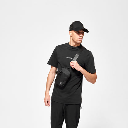 Model wearing 'OFFEND' mesh trucker cap, 'OFFEND ' black T-Shirt with 'OFFEND' text across centre of chest, wearing classic black 'OFFEND' crossbody bag with white 'OFFEND' logo in the bottom right corner of bag