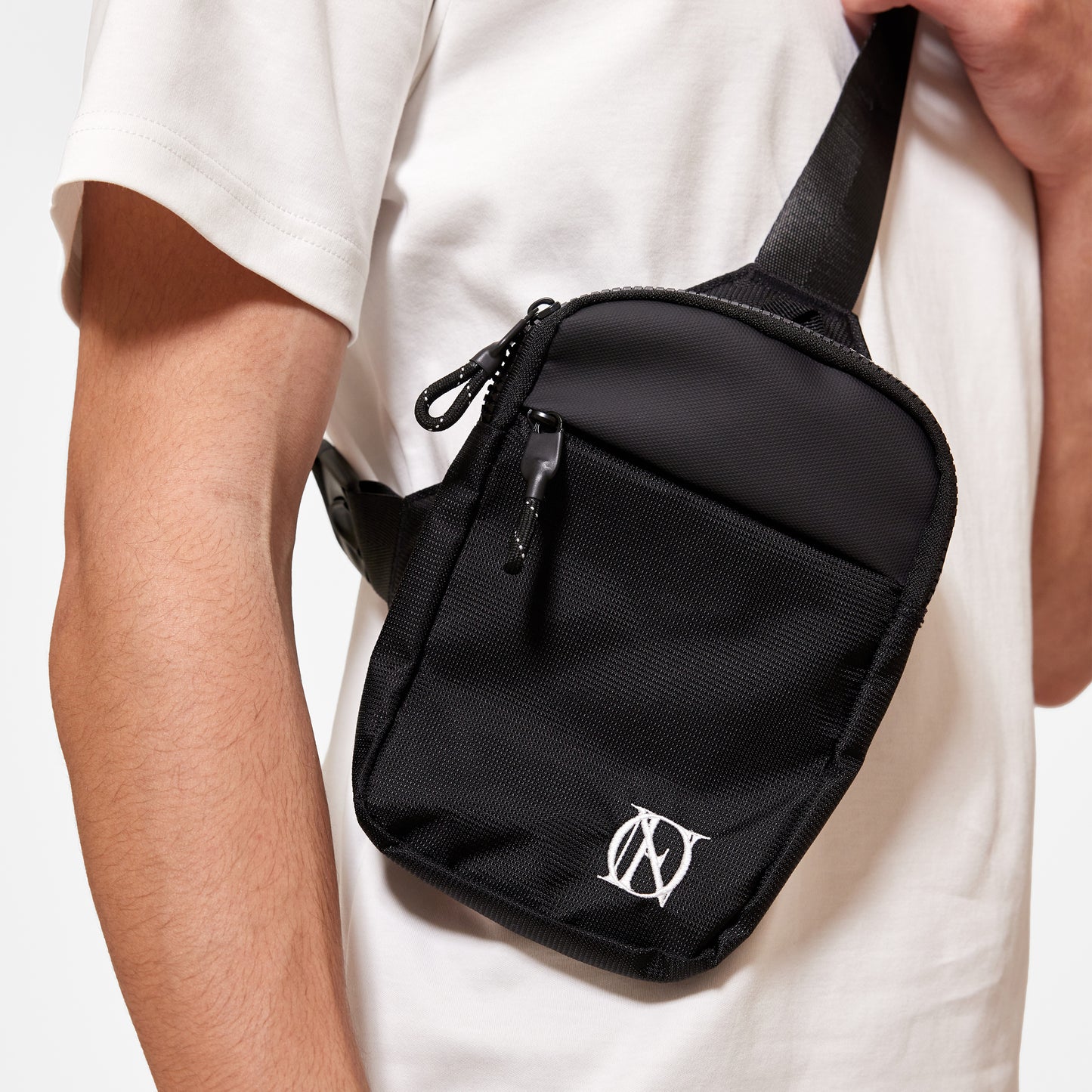 Close up of model wearing OG 'OFFEND' black crossbody bag with the white 'OFFEND'  logo in the bottom right corner