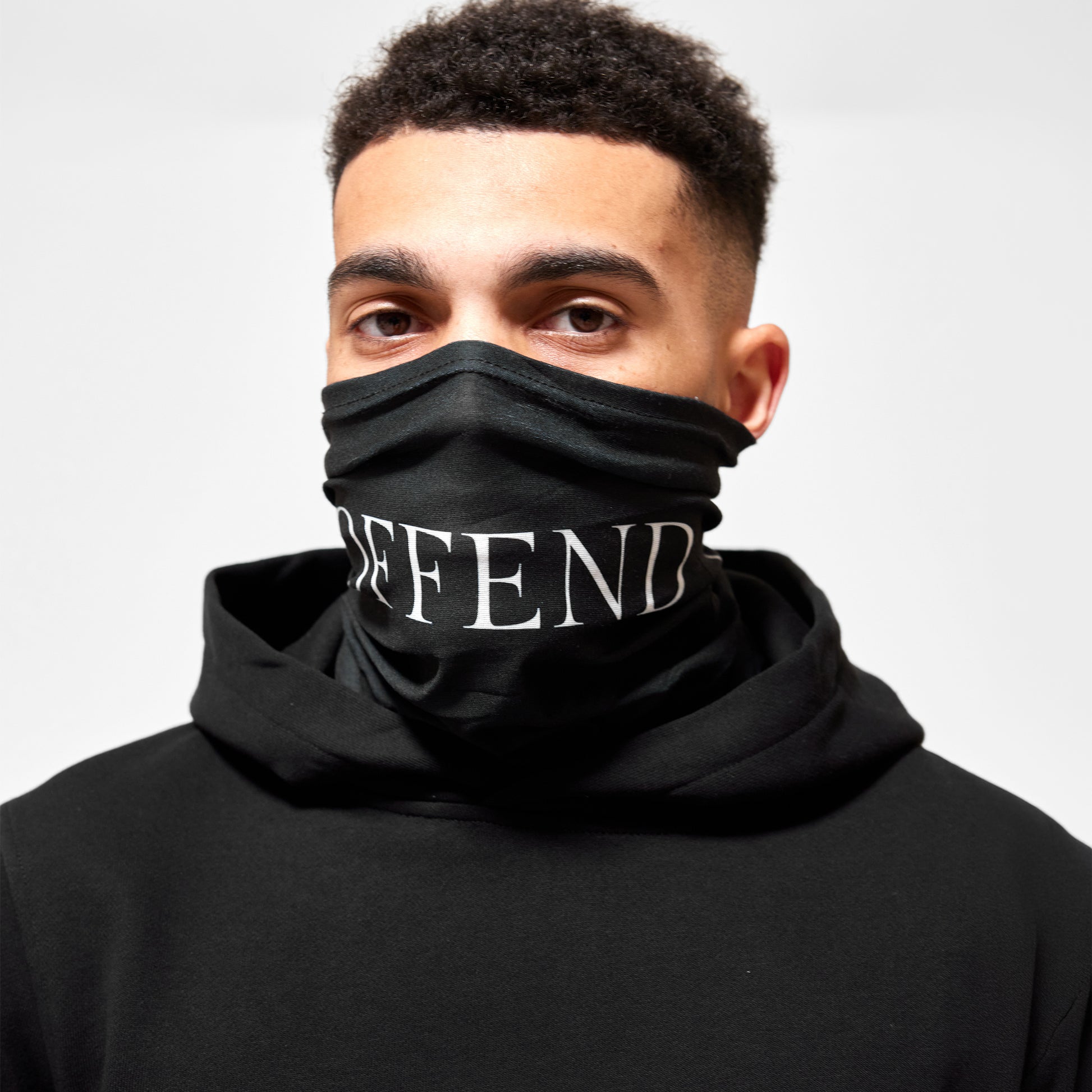 Close up of model wearing Black snood with 'OFFEND' text across face